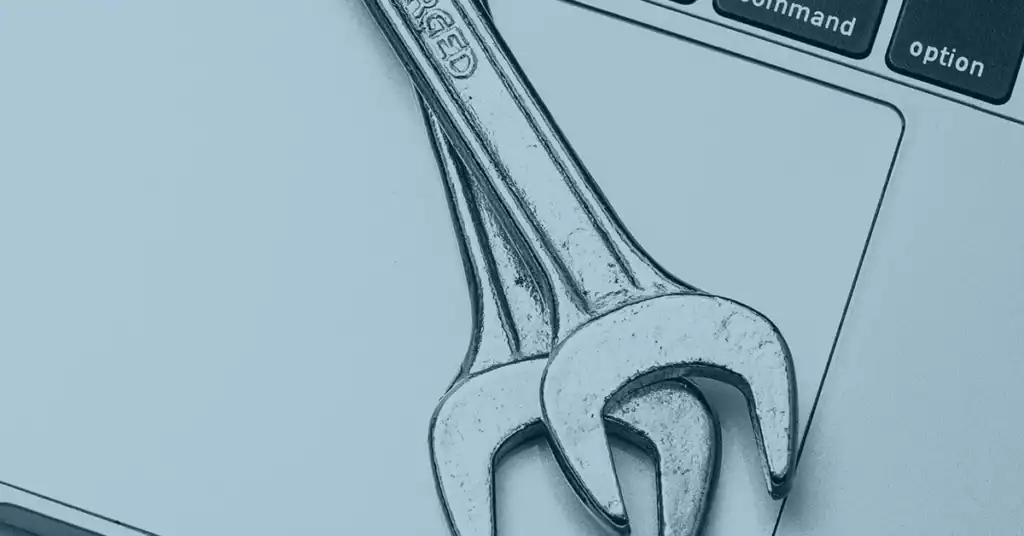 Wrench on a laptop keyboard representing network troubleshooting and support.