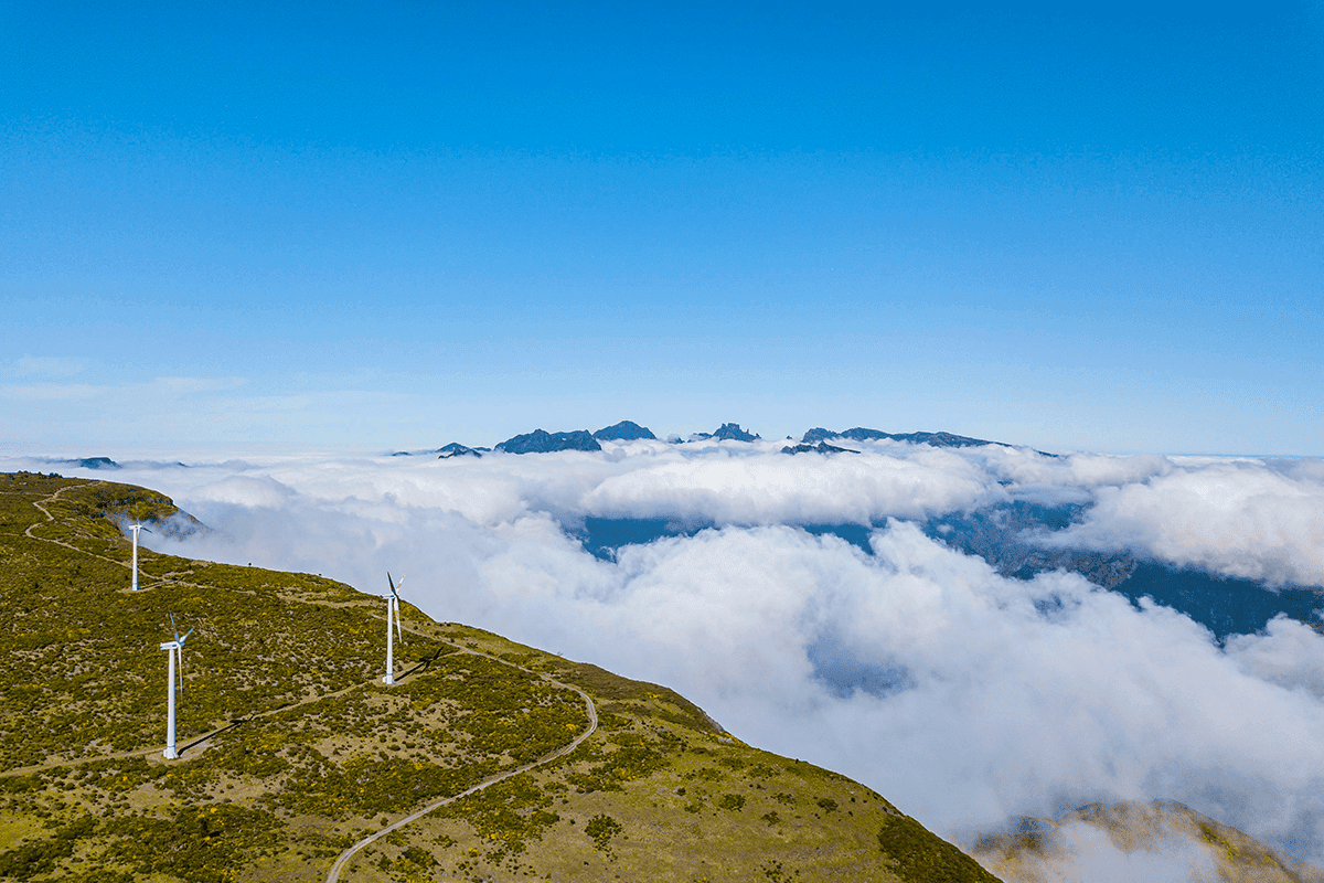 Photograph of wind turbines overlooking a clouded valley in Portugal