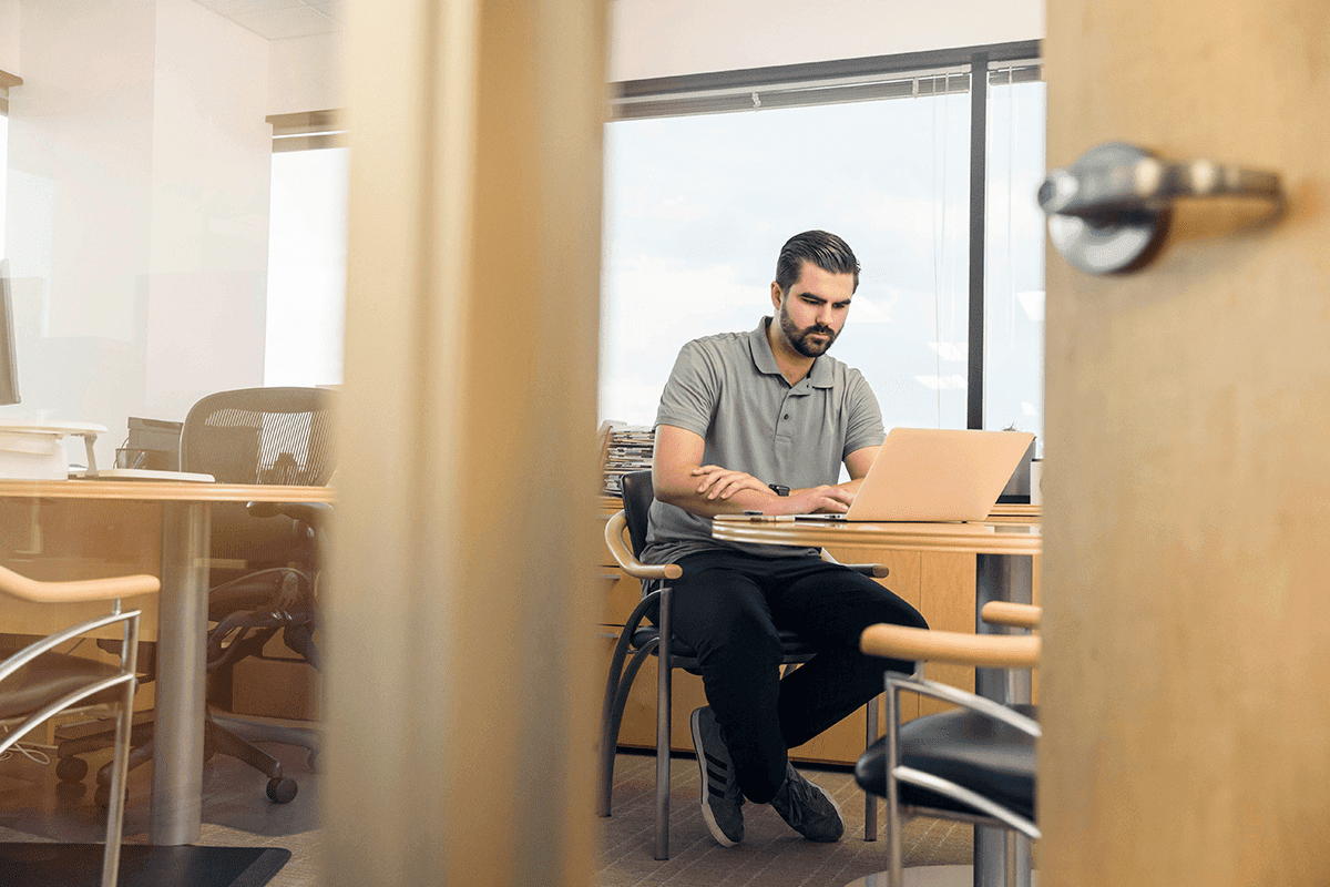 Man at desk working on a laptop