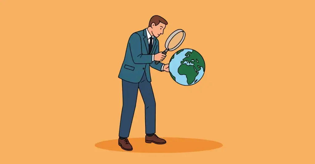 Businessman examining a globe with a magnifying glass for global analysis.