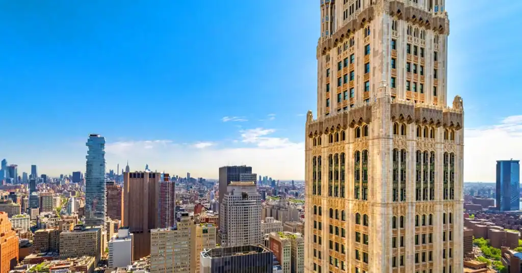 Tall skyscraper with intricate architecture in a vibrant cityscape.
