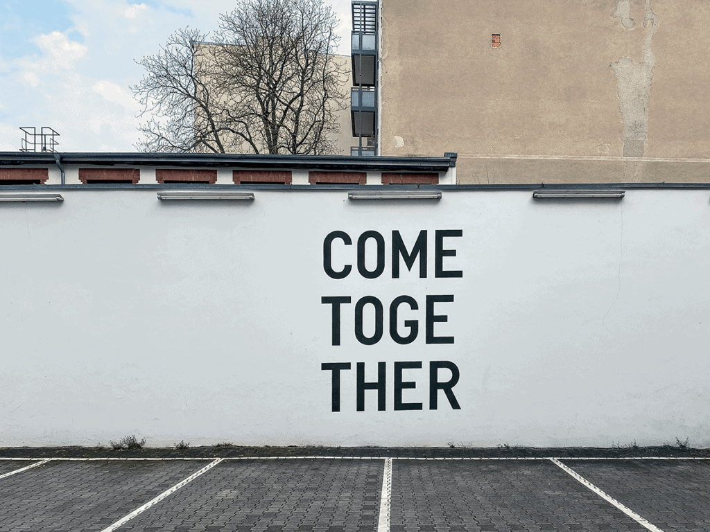 A photograph of a white wall with a stencil that says 