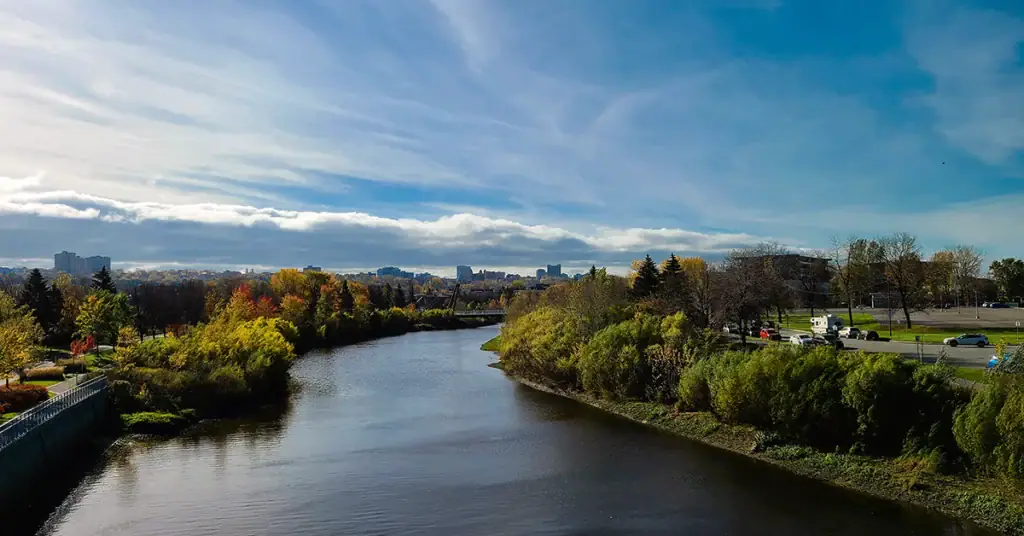 Beautiful river scene with lush trees and blue sky, ideal for outdoor and nature themes.