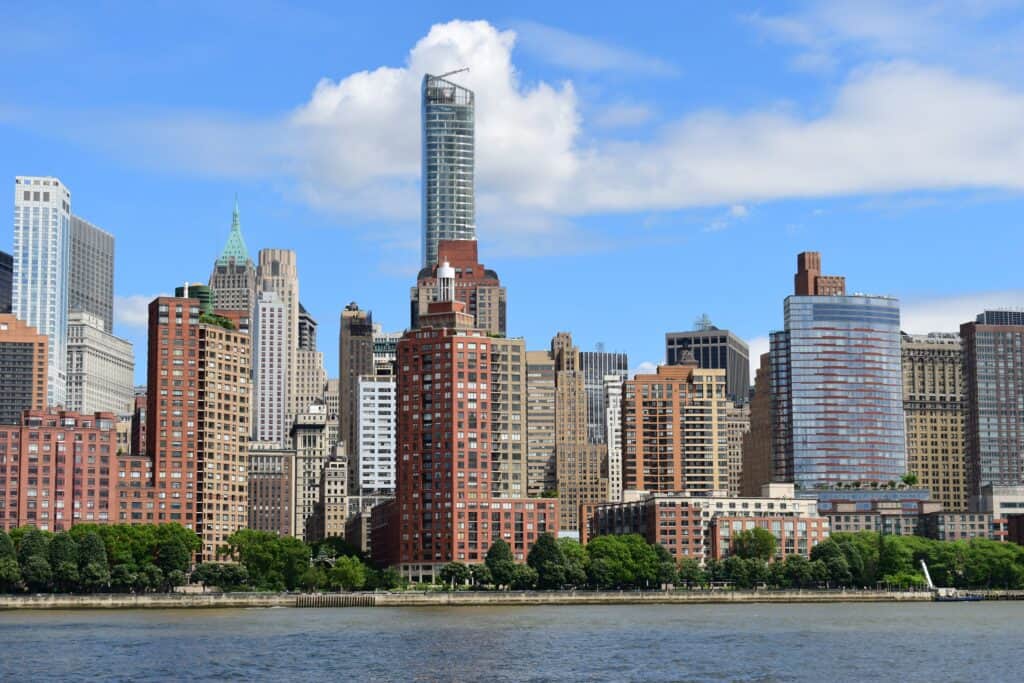 Manhattan skyline along Hudson River under blue sky
